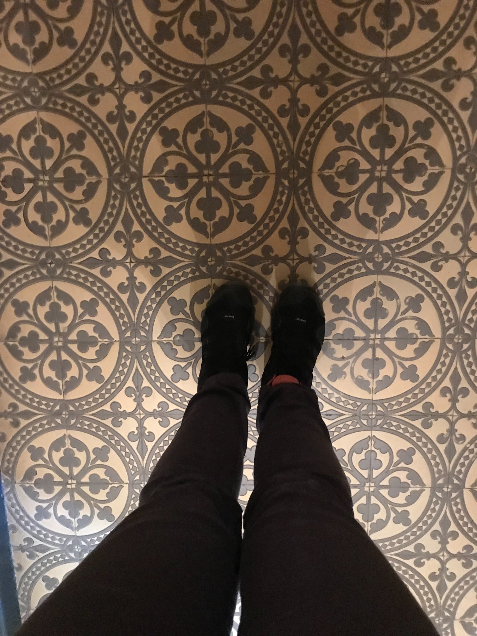 Historic patterned floor at Evenburg with Cora Hazelton standing on it
